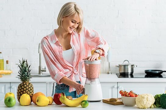The girl prepares a smoothie for weight loss in a blender